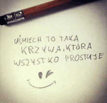 a pencil is laying on a piece of paper that says uśmiech to taka krzywa ktora wszystko prostuje