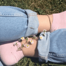 a person wearing blue jeans and pink socks with daisies on their feet