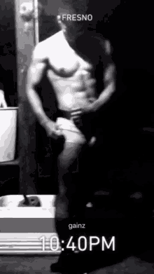 a black and white photo of a shirtless man with the time of 10:40 pm on the bottom