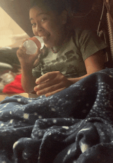 a young boy wearing a green shirt with a picture of a truck on it