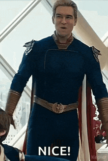a man in a superhero costume is standing next to a woman in a cape .