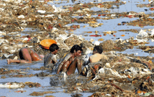 a group of people are bathing in a pile of garbage