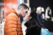 a man and a woman wearing face masks are kissing