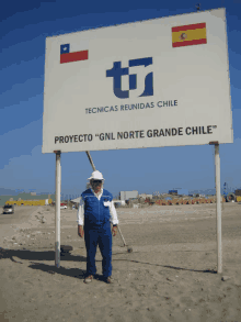 a man stands in front of a large sign that says tecnicas reunidas chile