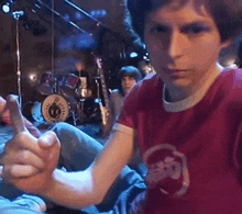 a young man wearing a red shirt with a skull on it