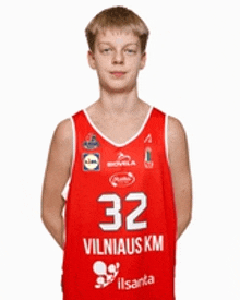 a young boy wearing a red basketball jersey with the number 32 on it