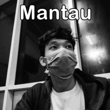 a black and white photo of a man wearing a face mask with the caption mantau