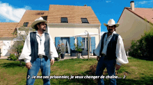 two men in cowboy hats are standing in front of a house with the words je me ses prisonnier je veux changer de chaine