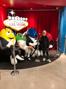 a boy standing in front of a sign that says fabulous las vegas nevada