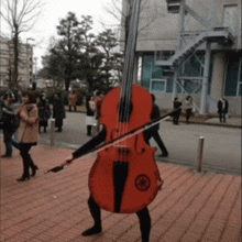 a person dressed as a violin is walking down a sidewalk