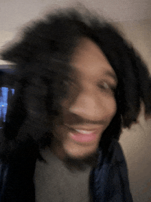 a blurry picture of a man with dreadlocks