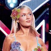 a woman with a flower in her hair and a bikini top