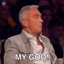 a man sitting in front of a microphone with the words my god written on his face