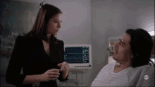 a woman is talking to a woman in a hospital bed with an abc logo on the bottom left