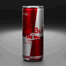 a red and silver can of red bull energy drink on a black background