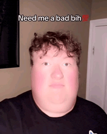 a man in a black shirt says " need me a bad bih " on his face