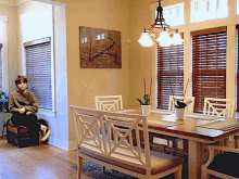 a boy in a wheelchair sits at a dining table in a dining room .