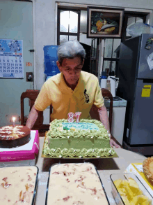 a man in a yellow shirt stands in front of a cake with the number 87 on it