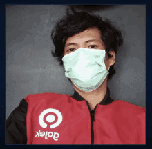 a man wearing a face mask and a gojek jacket