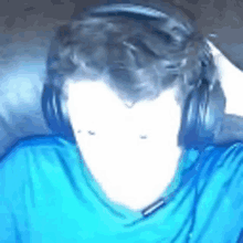 a man is wearing headphones and a blue shirt .