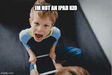 a young boy is holding a tablet with a caption that says im not an ipad kid