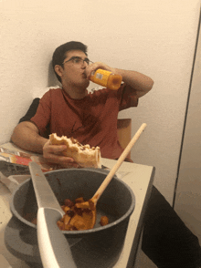 a man sitting at a table drinking orange juice