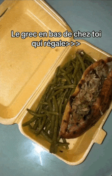 a styrofoam container filled with green beans and a sandwich with the words le grec en bas de chez toi qui regale