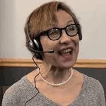 a woman wearing glasses and a headset with a microphone .