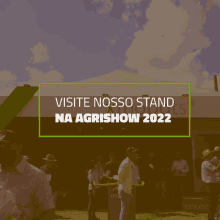 a sign that says visite nosso stand na agrishow 2022 in front of a group of people