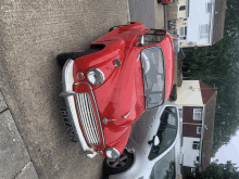 a red car with a license plate that says ht1040 is parked on the side of the road