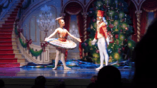 a nutcracker is standing next to a ballerina on stage