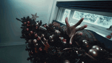 a man is reaching for a christmas tree with his hand