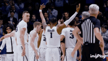 a group of basketball players are huddled around a referee and one of them has the number 1 on his back