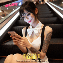 a woman with a tattoo on her arm is looking at her phone