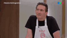 a man wearing a white apron that says paulo on it