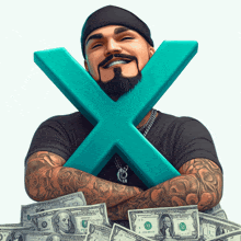 a man with a beard and tattoos is holding a large x in front of a pile of money