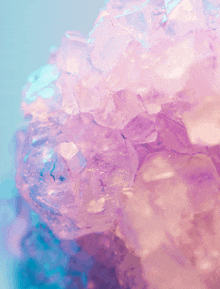 a close up of a purple and pink crystal on a blue background