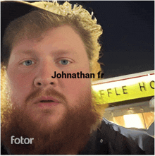 a man with a beard stands in front of a waffle house sign