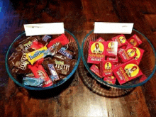 two bowls of candy on a wooden table one of which has a label that says butterscotch