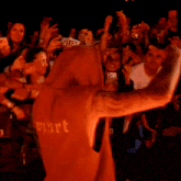 a crowd of people are taking pictures of a man wearing a hat that says hell on it
