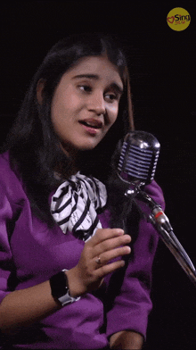 a woman singing into a microphone with the word sing on the bottom right