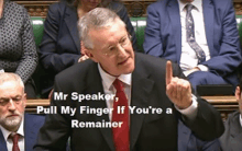 a man in a suit and tie is giving a speech in front of a group of people