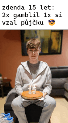 a young man is sitting on a stool holding a cake that says 15 on it