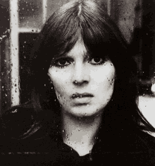 a black and white photo of a woman 's face with water drops on it