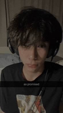 a young boy wearing headphones and a shirt that says " as promised "