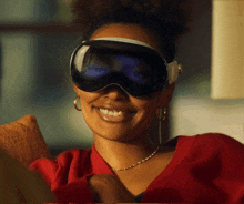 a woman wearing ski goggles and headphones smiles