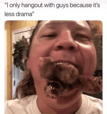 a man is eating a large piece of meat in his mouth .