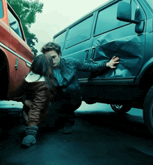 a man and a woman are kneeling next to a van