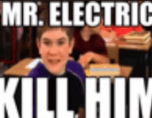 a boy is sitting at a desk in a classroom with the words `` mr. electric kill him '' written on it .