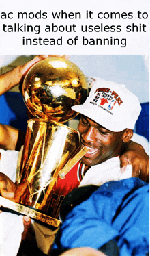 a man in a chicago bulls hat holds a trophy in his mouth